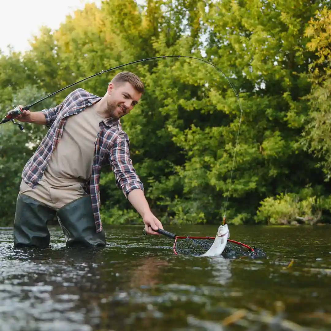 Guy catching a fish while fly fishing